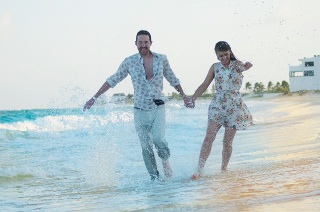 A happy couple holding hands on the beach