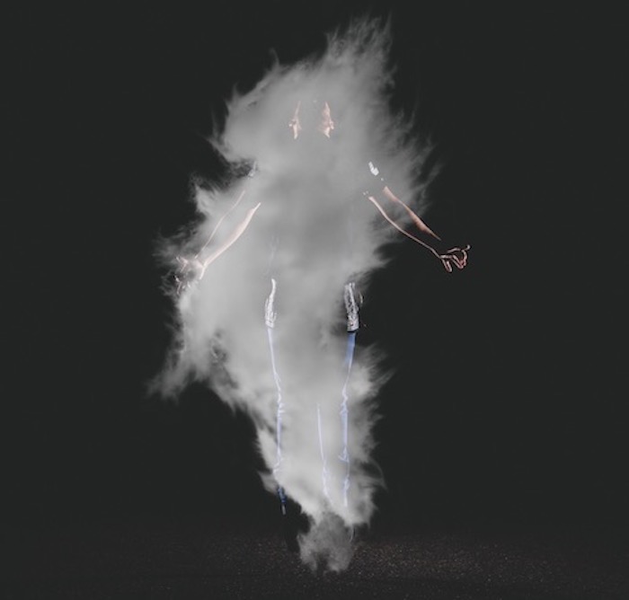 Cloud of white smoke in front of a man floating.