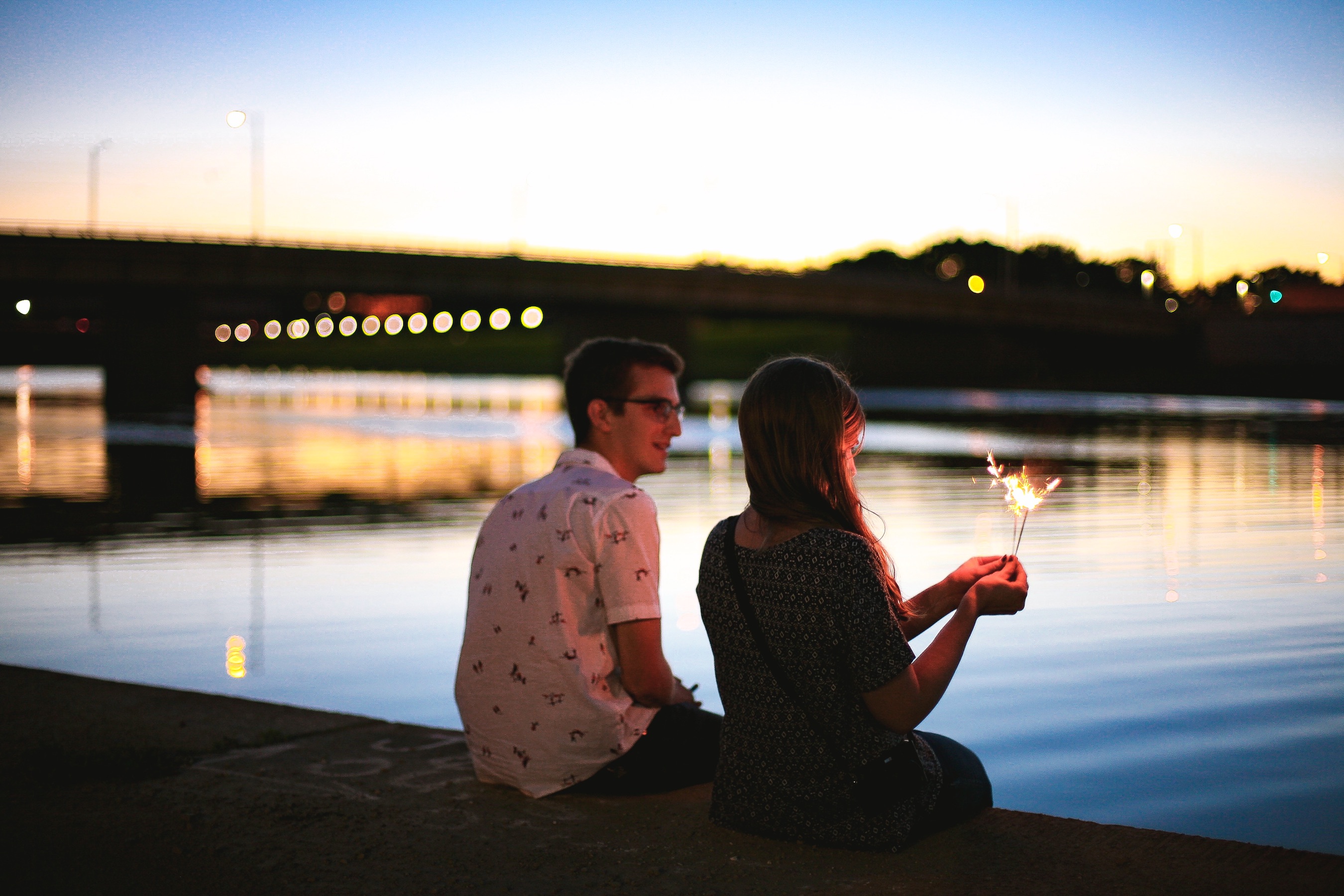 Happy couple sitting on pier