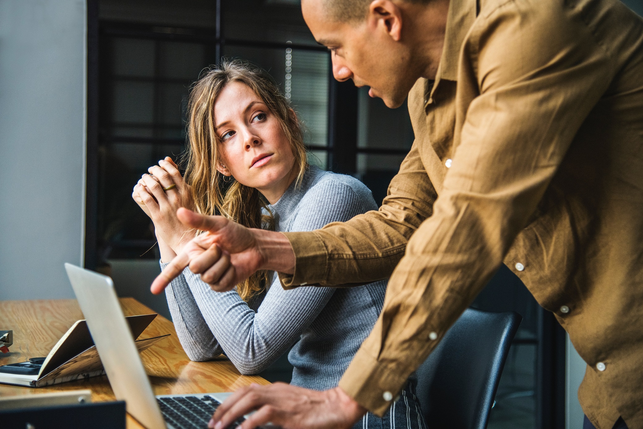 woman-at-desk-irritated-with-bossy-man