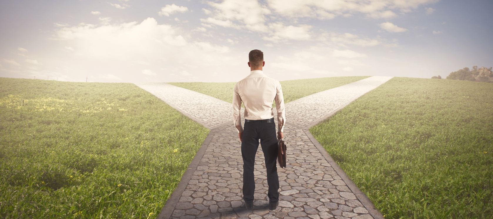 Man in a business suit standing at a literal crossroads