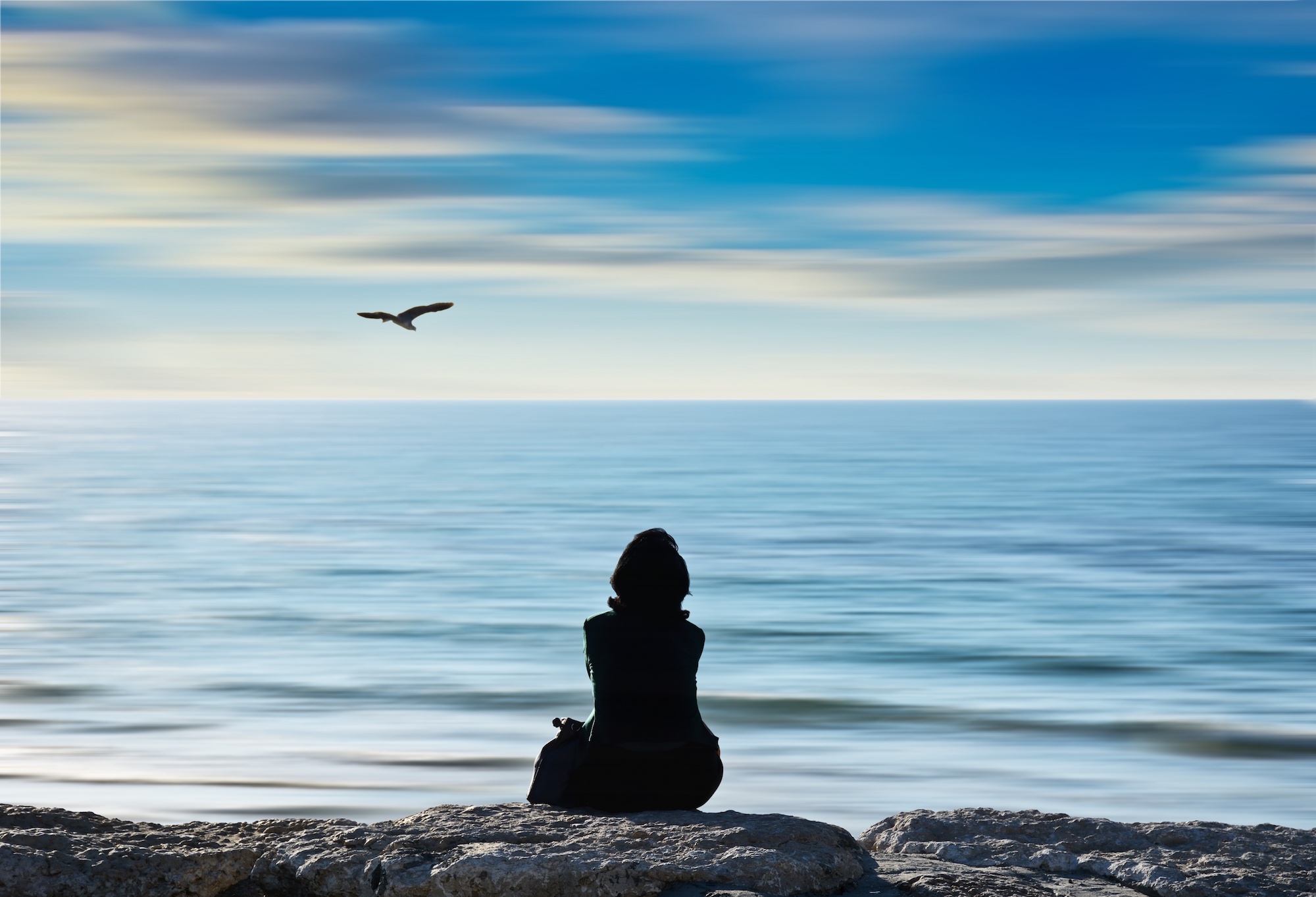 Person meditating near water