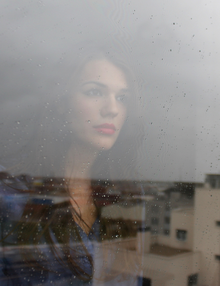 Reflective Woman Looking Out Window